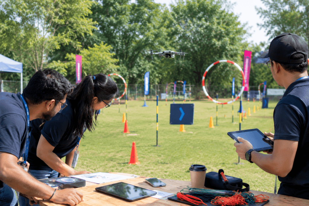 Corporate team preparing for a Flying Pursuit drone obstacle course challenge